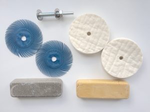 Plastic scratch removal kit with blue radial wheels, felt wheels, mandrel and compound bars